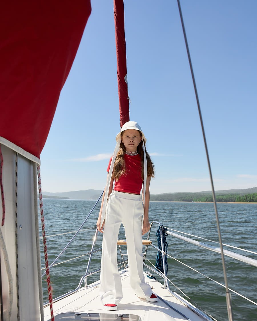 Red cropped tee and ivory trousers, confident stance