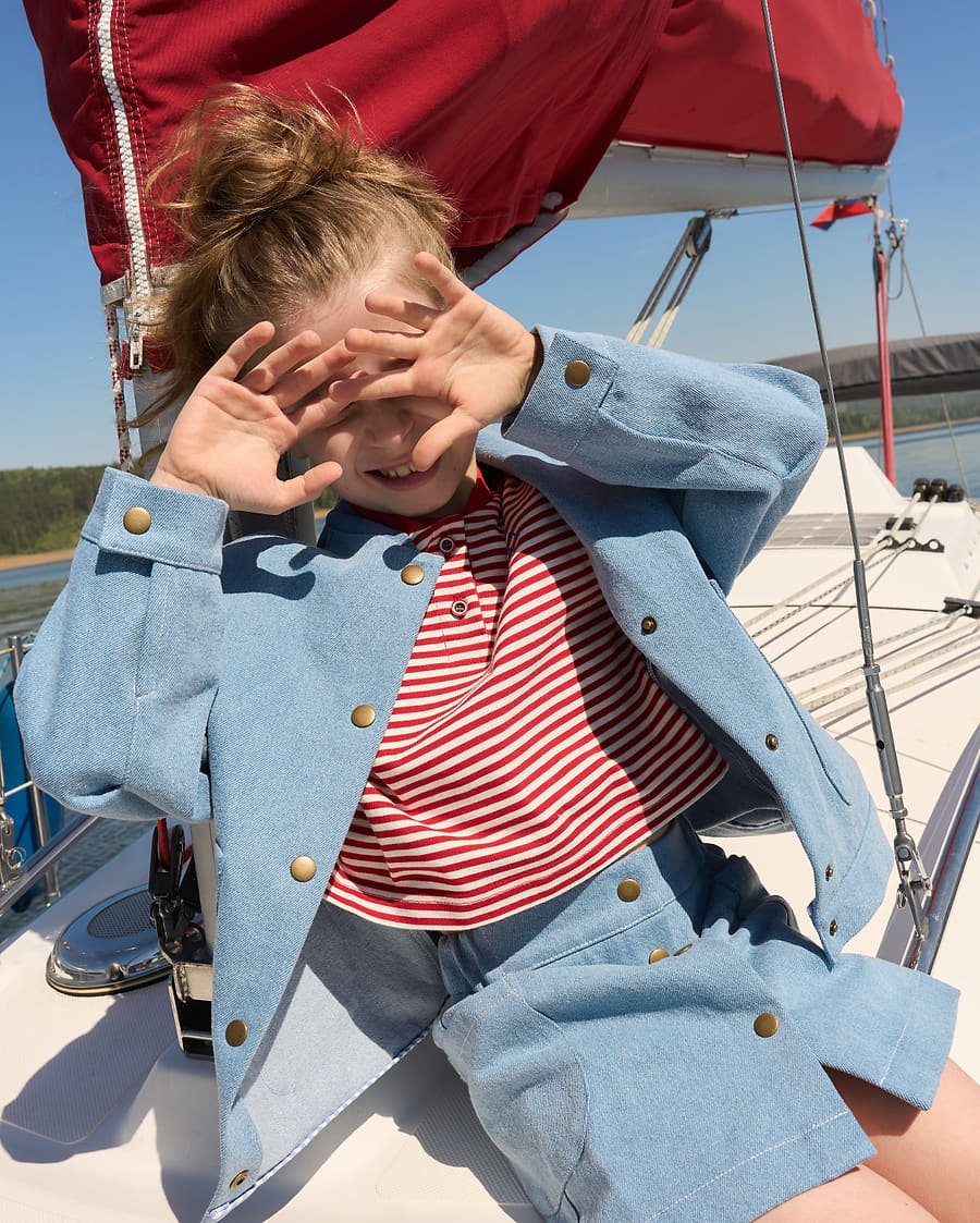 Denim jacket look, hands over face laughing